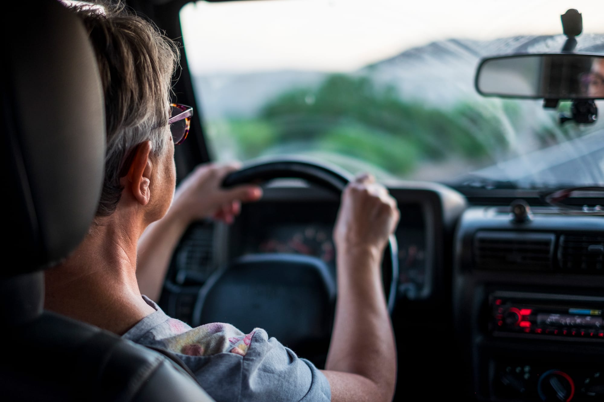 an older woman driving with glasses and reduced visibility