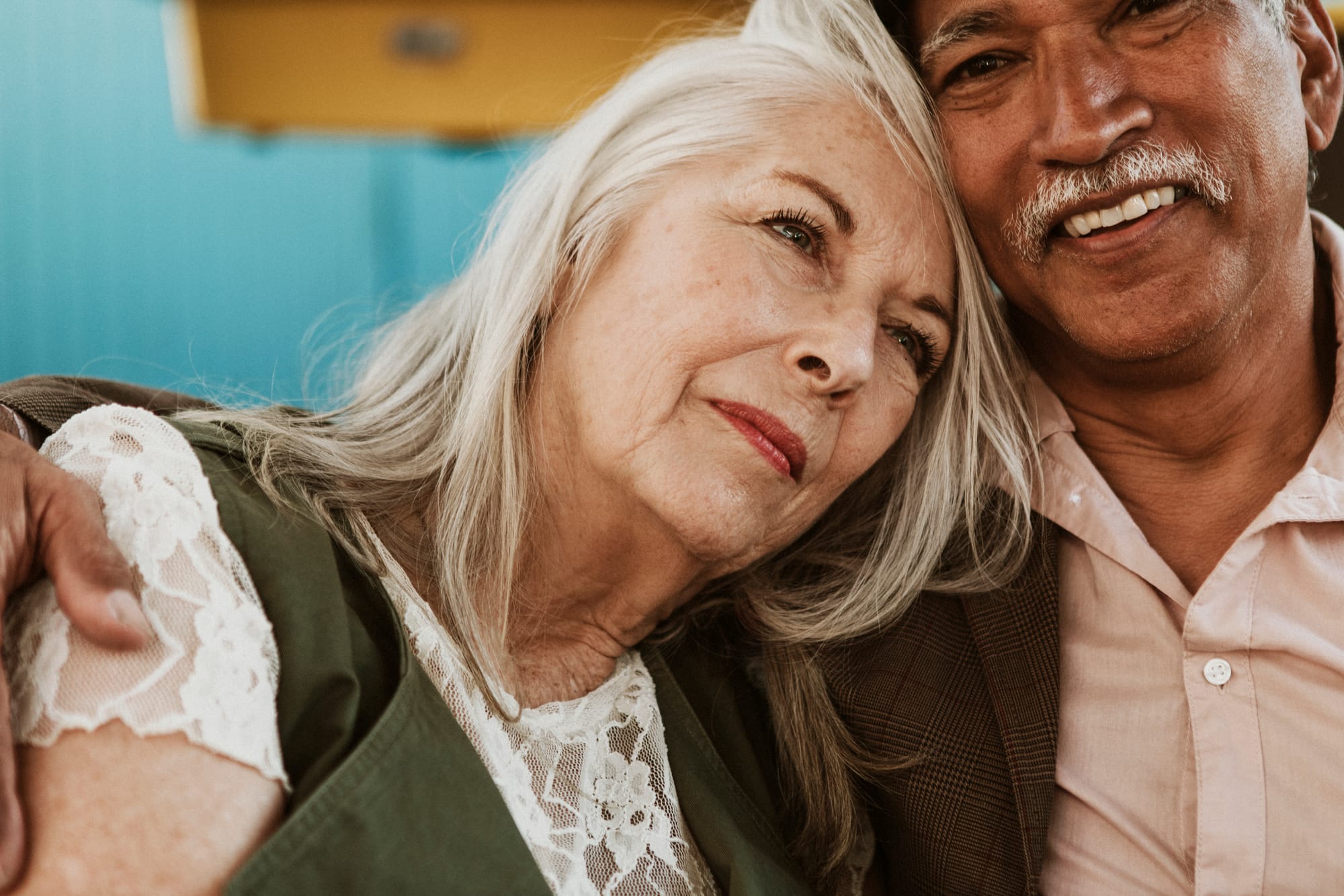 an older woman leaning on a mans shoulder for comfort