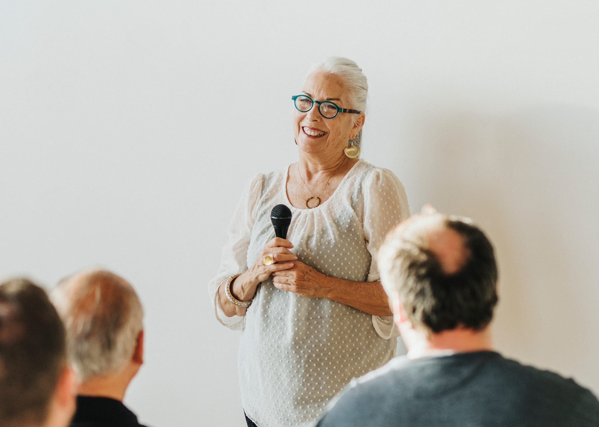 A woman in a support group for aging and caregiving holding a microphone