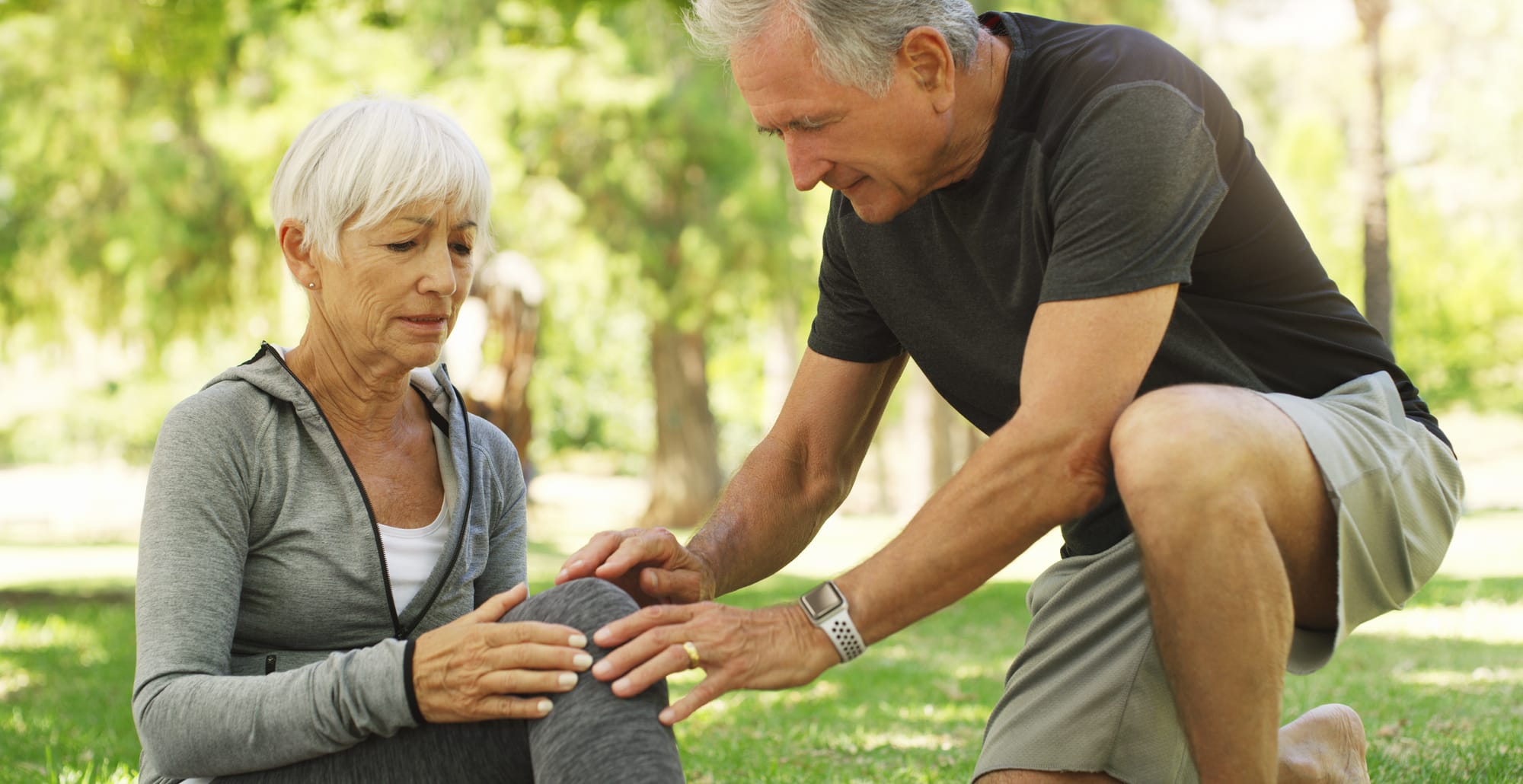 An aging couple touching a woman's knee after some pain while running