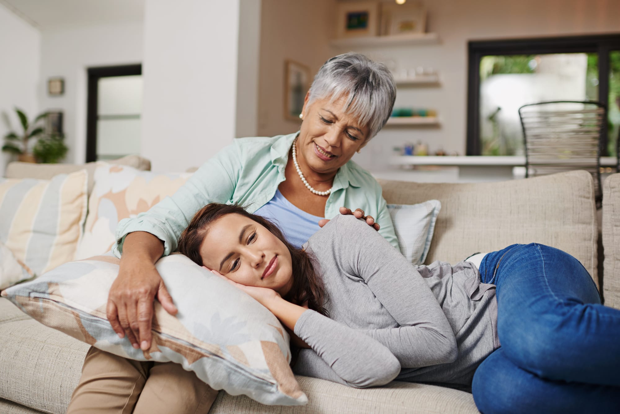 an exhausted burned out caregiver sleeping on the lap of an older adult