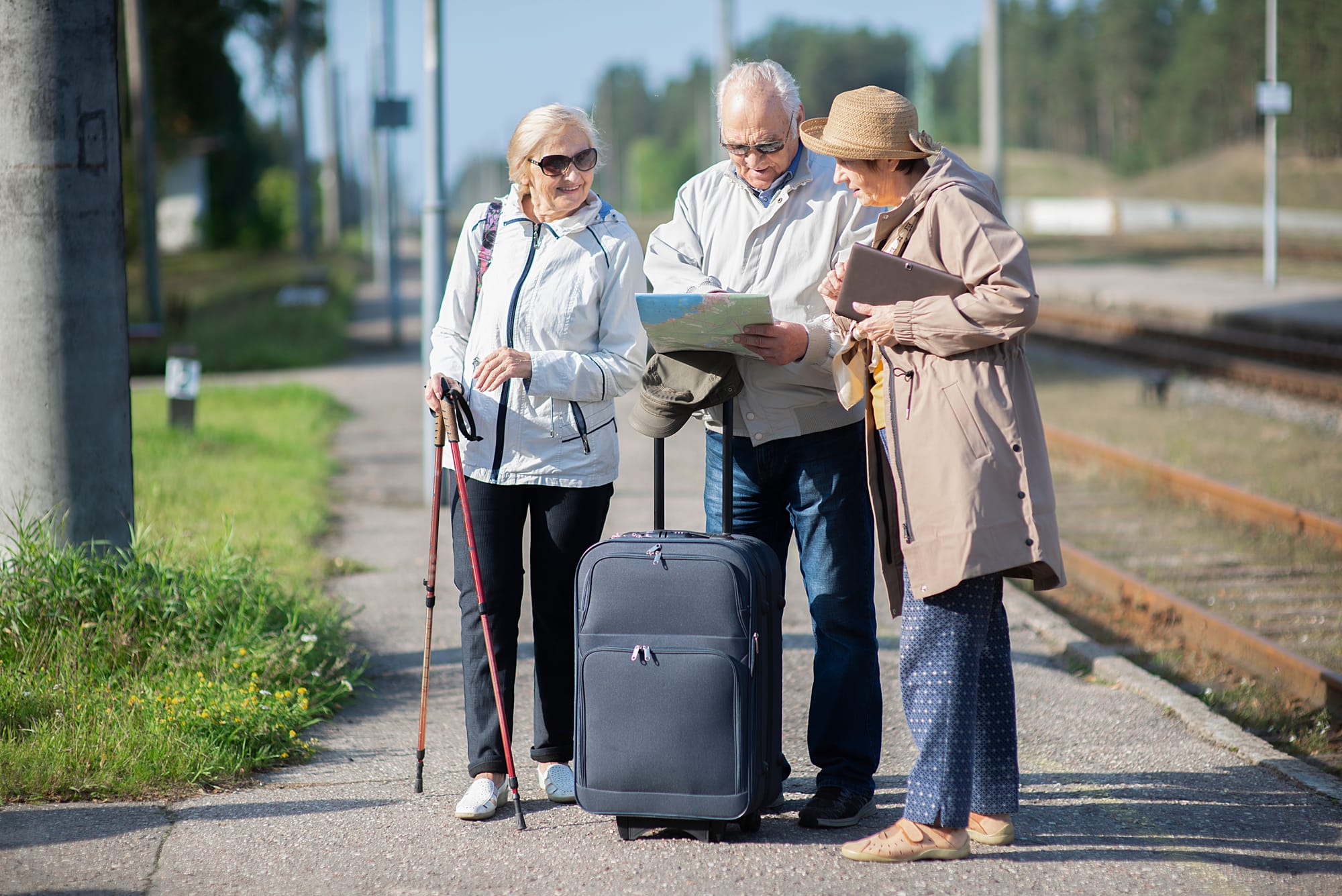 older adults on a trip with suitcases and a map