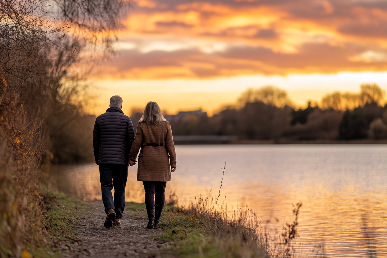 a couple walking by the lake at sunset