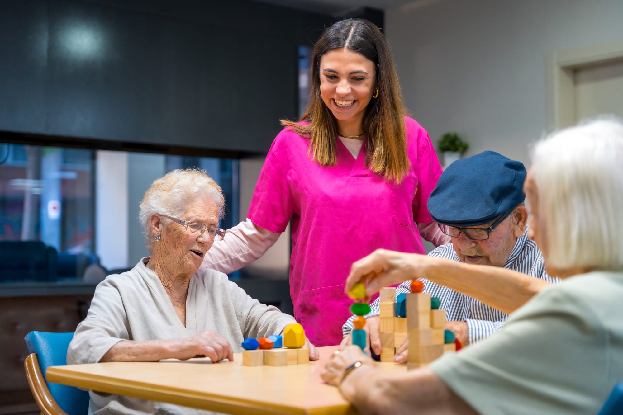 an older woman with dementia playing with blocks with her caregiver under palliative care