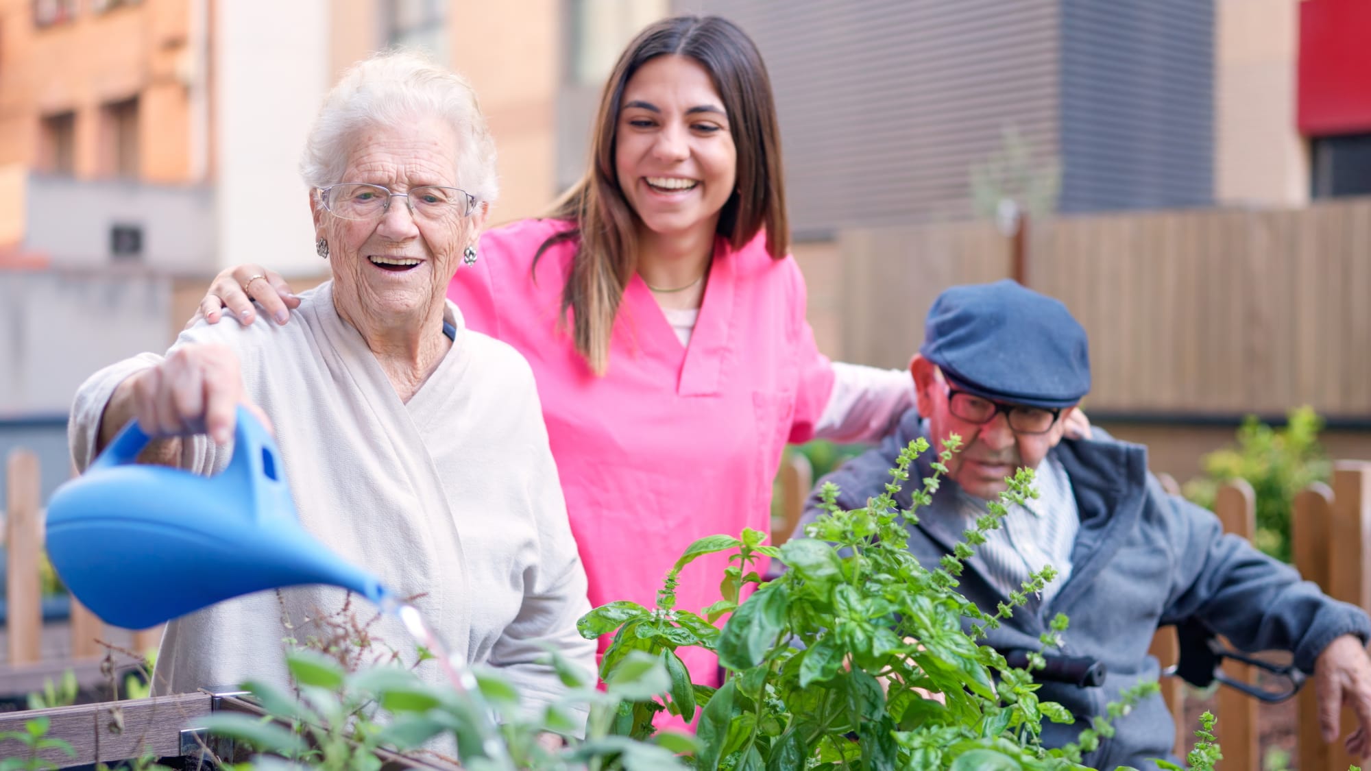 an older woman with dementia watering her plants with her caregiver under palliative care