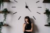 A woman sitting in front of a clock thinking about how much time she has left to live