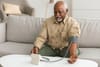 an older man checking his blood pressure