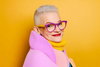 a fashionable older woman with purple glasses
