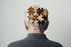 a man with puzzle pieces symbolizing forgetting details from alzheimers