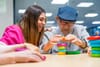 an older man with dementia playing with blocks with her caregiver under palliative care