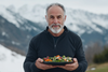 an older man on a mountain eating a really healthy dish - SeriousAging.com